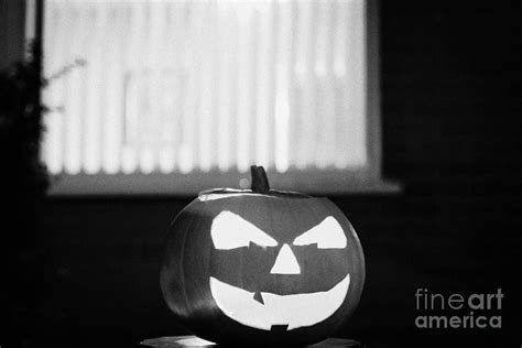 Illuminated Halloween Pumpkin Jack O Lantern Outside The Window Of A