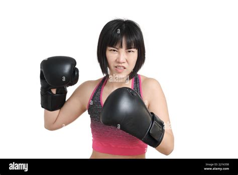 Young Asian Woman Wearing Boxing Gloves Winding Up A Punch Isolated