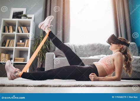 Girl In Virtual Glasses Stretching Legs With Elastic Band Stock Image