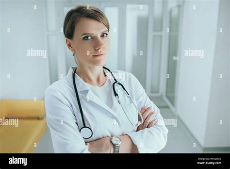 Middle Aged Female Doctor Standing In Hospital Corridor With