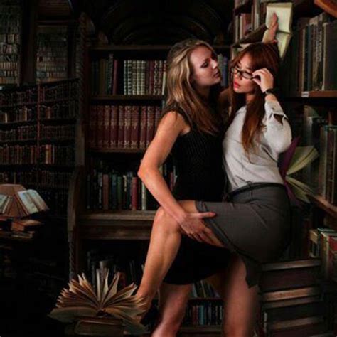 Two Women Are Kissing In Front Of A Bookshelf With Many Books On The Shelves