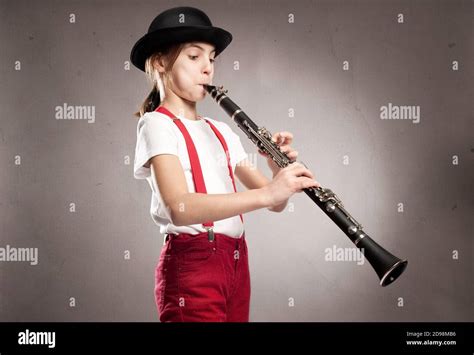 Little Girl Playing Clarinet On A Gray Background Stock Photo Alamy