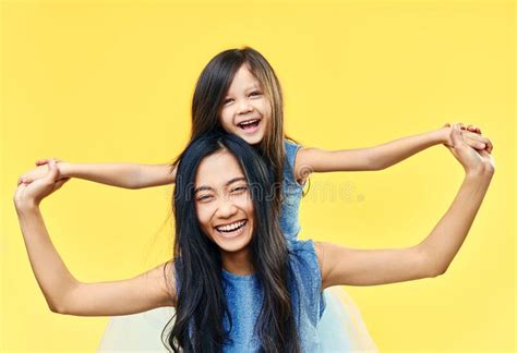 Feliz Madre Y Su Hija Se Divierten Juntos En El Fondo Amarillo Imagen
