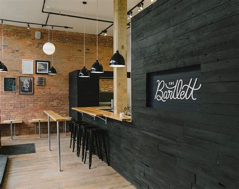The beautiful live edge wood and steel pipe legs give this piece a unique industrial look while maintaining its rustic feel. The Bartlett Cafe Interior | Black washed wood with ...