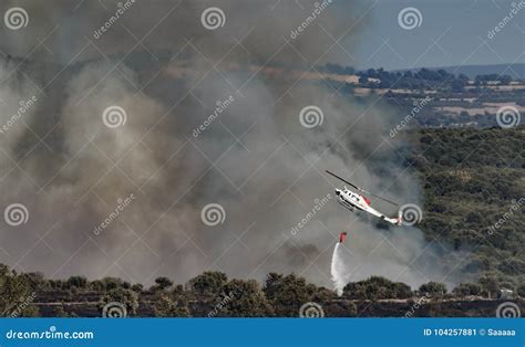 Fire In The Wilderness With Helicopter Throwing Water Editorial Photo