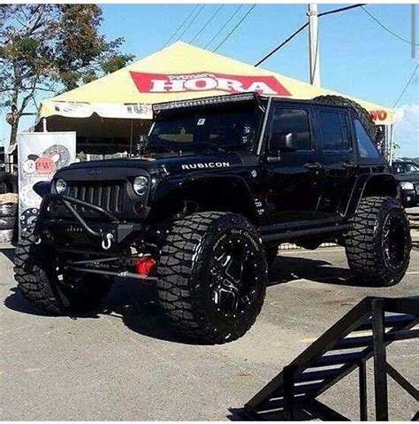 A Black Jeep Is Parked In Front Of A Building With A Sign That Says