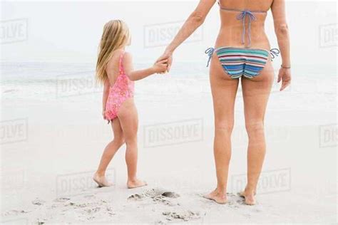 Girl And Mother Holding Hands On Beach Stock Photo Dissolve