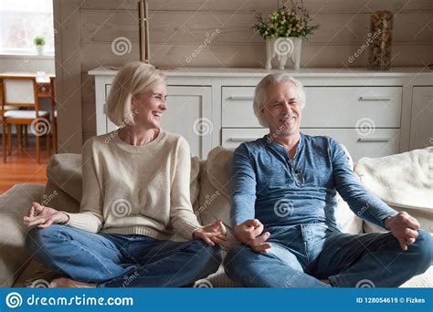 Old Couple Having Fun Laughing Doing Yoga Together At Home Stock Image