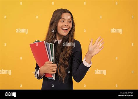 Happy Teen Girl Hold School Copybook For Homework Studying On Yellow