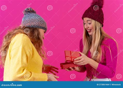Joyful Young Female Friends Embracing Each Other While Holding A T Box With A Big Red Bow