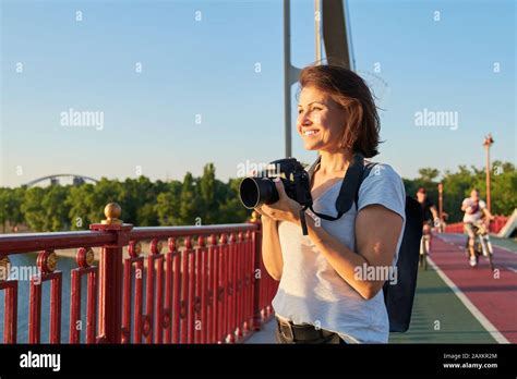 Mature Woman Photographer With Camera Taking Photo Picture Stock Photo