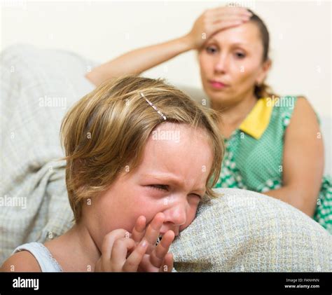 Crying Child Against Unhappy Woman Having Quarrel At Home Stock Photo