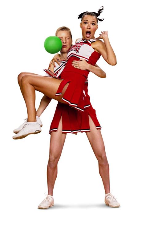 Two Women In Cheerleader Outfits Holding A Green Ball