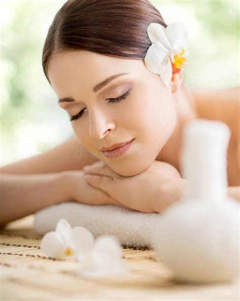 Young And Beautiful Girl Relaxing In Spa Salon Massage Therapy Over Seasonal Summer Or Spring