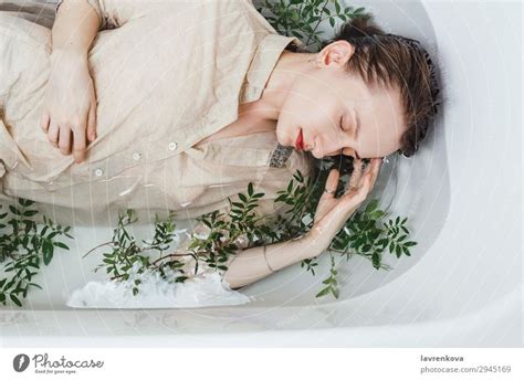 Woman Lying In Bathtub Filled With Charcoal Water A Royalty Free