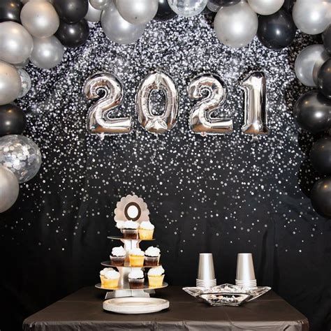 A Table Topped With Silver And Black Balloons