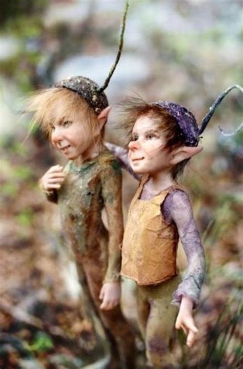 Two Dolls Standing Next To Each Other In The Woods With Mud On Their