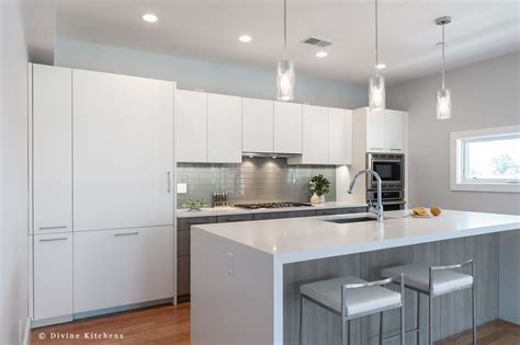 A Kitchen With White Cabinets And An Island Countertop In Front Of Two