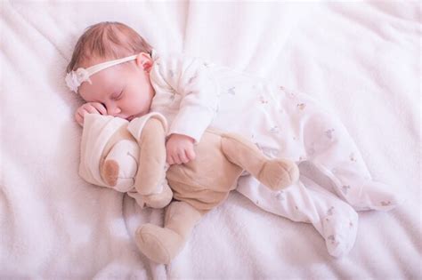 Lindo Bebé Durmiendo En Pijama Blanco Con Osito De Peluche Foto Premium