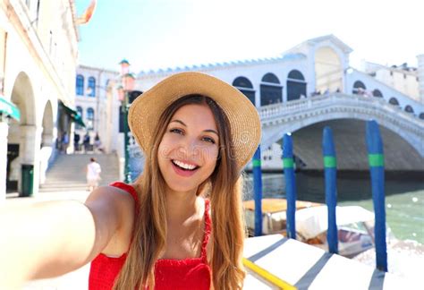 venice tourist girl on summer holidays taking selfie photo with famous rialto bridge venice