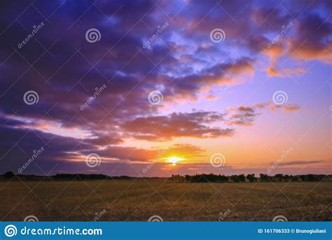 Superb Sunrise In The Countryside Above A Field With Its Rays Shining