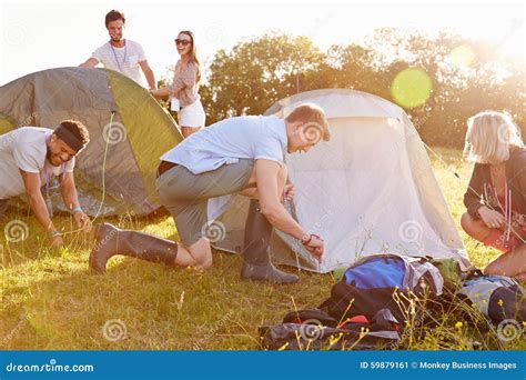 Group Of Young Friends Pitching Tents On Camping Holiday Stock Image