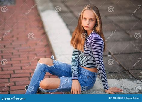 Young Teenage Poses For Photo Blonde Girl In Jeans And Blouse Stock