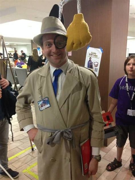 A Man In A Trench Coat And Top Hat Standing Next To Other People