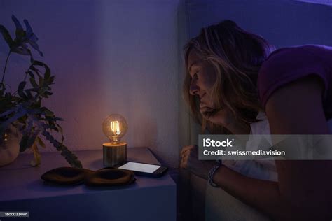 photo libre de droit de femme réveillée dans son lit À laide dun téléphone portable la nuit