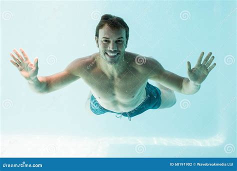 Portrait Of Shirtless Smiling Boy Swimming Underwater In Swimming Pool