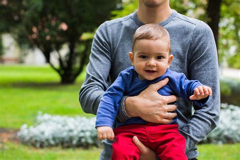 Anonymous Man Holding Baby Boy In The Park By Stocksy Contributor
