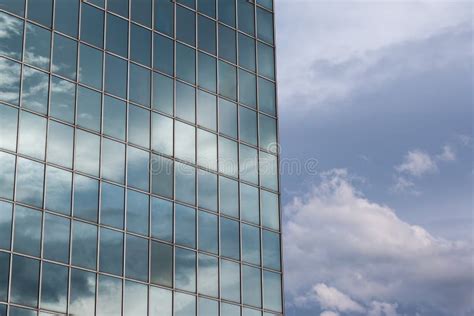 Modern Building Glass Facade Reflecting Cloudy Blue Sky Stock Photo
