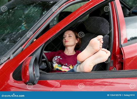 Young Woman Driver Resting In A Red Car Put Her Feet On The Car Window