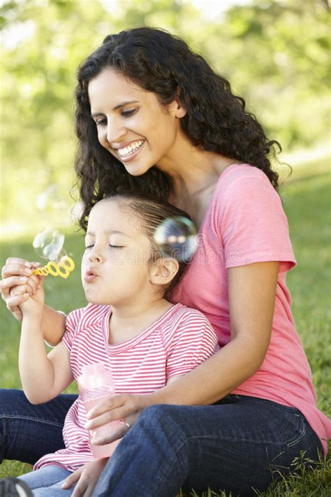 Hija Hispánica De La Madre Y Del Adulto Que Se Relaja En Parque Imagen