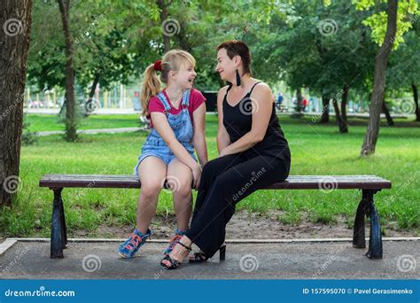 Mother And Daughter Sitting On A Bench In The Park Stock Photo Image