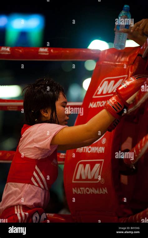 Sweaty Female Muay Thai Kickboxer Facing Red Corner Crouching Resting Between Rounds At Amateur