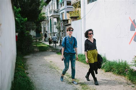 Two Friends Walking In The Street By Stocksy Contributor Davide