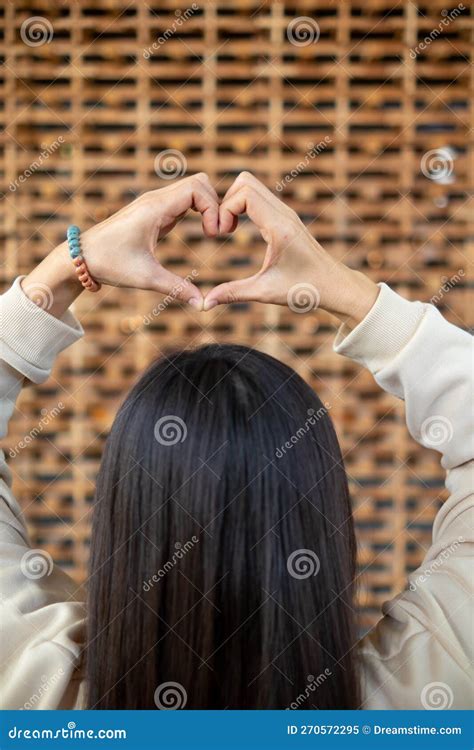 Young Woman Shows Her Hands Above Her Head Making Heart Symbol To Show Friendship Love And