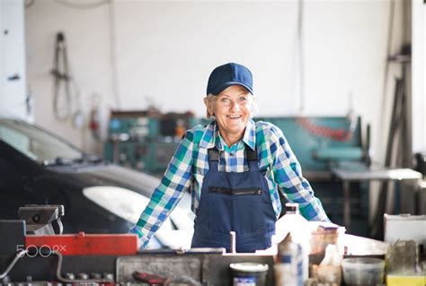 Senior Female Mechanic Repairing A Car In A Garage Woman Mechanic