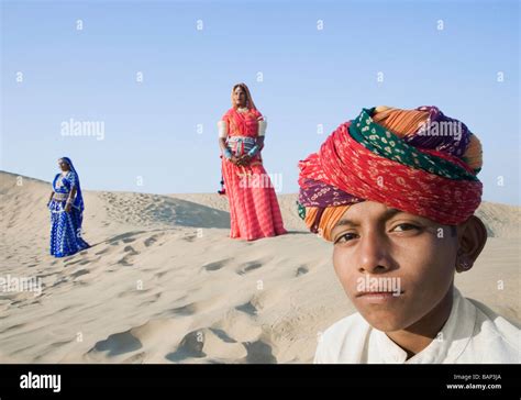 Boy With Two Women Standing In The Background Thar Desert Jaisalmer