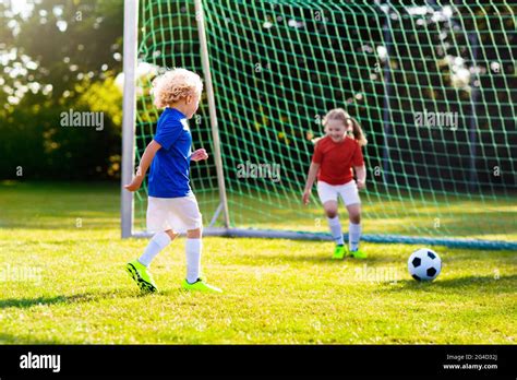 Kids Play Football On Outdoor Field Children Score A Goal During