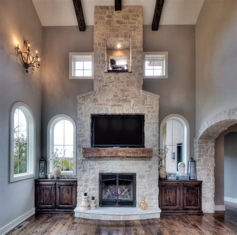 White country squire stone veneer is the featured wall stone in a mortared stone veneer masonry application for the fireplace stone, with a cozy seating area and floating wood shelves for the perfect home decor. Warm up your living room with a stone veneer fireplace. | Stone fireplace makeover, Stone ...