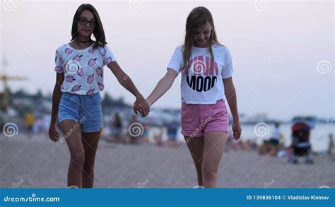 Young Female Couple Holding Hands On Beach In The Evening Two Girls