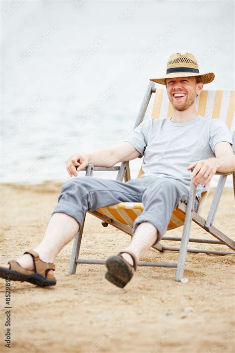 mann sitzt im liegestuhl am strand stock foto adobe stock