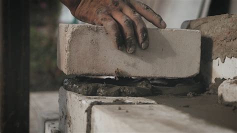 Construction worker or mason laying bricks and creating walls. Bricklayer laying bricks to make 