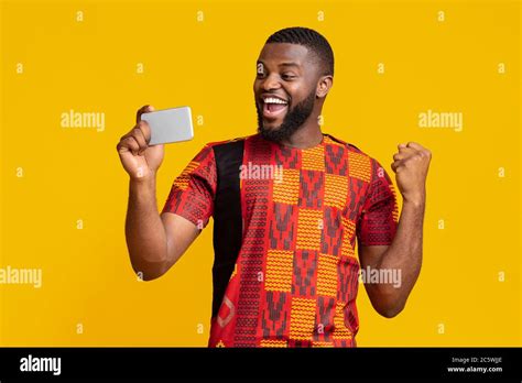 Happy Black Man Holding Phone And Expressing Happiness Stock Photo Alamy