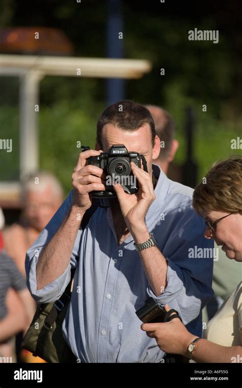 Man Taking A Photograph With A Nikon F90x Slr Camera Stock Photo Alamy