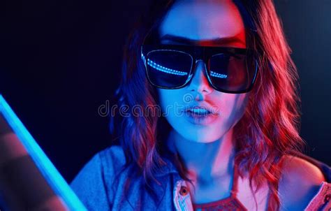 Portrait Of Young Girl In Sunglasses In Red And Blue Neon In Studio