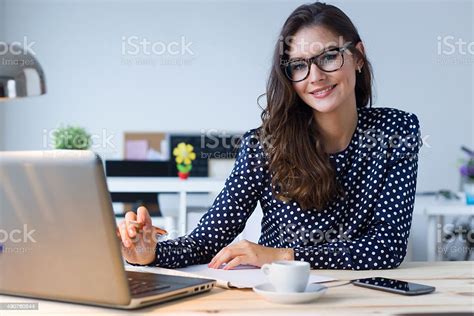 Beautiful Young Woman Working With Laptop In Her Office Stock Photo