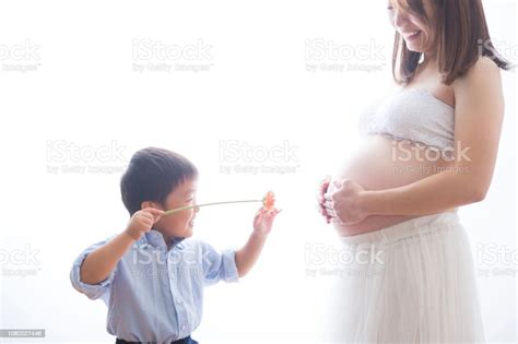 Pregnant Woman Playing With A Boy And A Flower Stock Photo Download